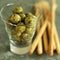 Close up of some breadsticks and a small glass of olives. Conceptual image shot