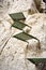 close up of some green steps to climb a vertical white stone of the wall of a mountain helping to hikers to save the gap to get