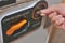 Close up of some part of vending machine with coin return lever with man hand holding coin