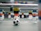 A close-up of some players and a soccer ball on a foosball table.