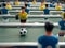 A close-up of some players and a soccer ball on a foosball table.