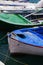 A close up of some small wooden colorful fishing boats at the po