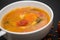 close up on soup with tomato, lentil and potato, rustical background, top view