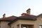 Close up of spacious brown shingle roof of modern luxurious expensive residential cottage house with three chimneys, big windows