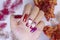 Close up sparkling red color gel polish painting 3D rose flower decorate d with shiny rhinestone and glitter on fashionista woman