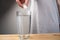 Close up sparkling water glass with dissolving effervescent aspirin pill standing on wooden table