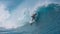 CLOSE UP: Spectacular shot of young surfboarder riding a big emerald tube wave.