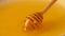 Close up spinning wooden dipper in honey bowl