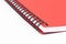 Close up of spirall notebook with red cover on white background