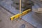 Close up of spirit level placed on outdoor pavers or tiles with directional cord on a prepared flat sand surface