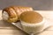 Close-up sponge cake and cream roll bread on little dish that on wooden table.