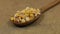 Close-up, spoon rotation with a pile of corn grains lying on burlap.