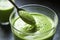 close-up of a spoon stirring a healthy green smoothie