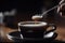 close-up of spoon stirring sugar into warm cup of coffee