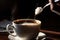 close-up of spoon stirring sugar into warm cup of coffee