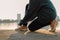 Close up Sport runner hands tying running shoes on street outdoors in the city. Woman preparing for run exercise workout in the mo