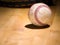 Close up sports background image of an old used weathered leather baseball laying in front of a ball glove on a wood butcher block