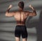 Close up of sports man muscular back. Bodybuilder show biceps