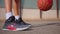 Close-up of sportswoman bouncing basketball ball training on ground floor of the court. Basketball player. Workout