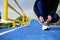 Close up of sporty caucasian woman kneeling and tying shoelace on court in the morning