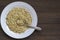 Close up sprouted buckwheat with spoon in white plate on wooden table