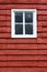 Close up square white window inred wooden barn.