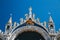 Close up of St Mark`s Apostle, angels and golden lion on the top of Basilica di San Marco, St Mark`s Basilica in Venice