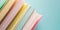 Close-up of a stack of books on a pastel blue background with copy space