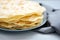 Close up stack of pita, Arabic bread, flatbread on gray wooden background. Soft focus. Traditional arabian food