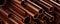 Close up of stacked copper pipes or tubes background, construction or manufacturing materials concept