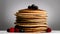 Close-up of stacked pancakes, blueberries and raspberries, isolated on white background