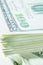 Close up of stacks of hundred US Dollar bills. Shot with shallow depth of field. Selective focus. Vertical image