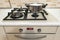 Close-up of stainless steel cooking pot on gas stove in contemporary upscale modern home kitchen. Selective focus on pot.