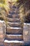 close up of a stair made with steps of concrete and stones in a garden. Vertical photo