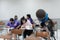 Close up of a stand microphone on the lecturer table inside college classroom with blure students as background