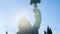 Close-up of statue of Neptune. Stock footage. Trident of statue of Poseidon rises against blue sky and is illuminated by