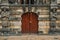 Close-up of statues around wooded door in front of the gothic City Hall building of Gouda in a cloudy day.