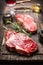 Close up of steak with rosemary and spices on dark rustic background.