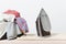 Close up steam iron colorful clothes washed laundry on white background. Housekeeping. Copy space advertisement. Place for text.