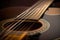 close-up of steel-string guitar, with strings and fretboard in sharp focus