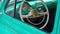 Close-up steering wheel of retro car. Vintage green automobile part closeup.