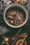 Close up of stewed beef meat in cooking pot with herbs, spices and kitchen utensils, top view. Country`s meat dishes. Slow cookin