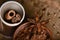 Close-up of a sticks of cinnamon, cocoa and star anise in a cup, grains of cardamom, on a wooden background, selective focus, marc