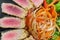 Close Up Still Life of Roasted Tuna Steaks Crusted with Herbs and Sesame Seeds on Dark Gray Surface