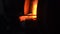 Close up of stiring the coals in the stove with a poker on black background. Stock footage. Side view of the burning