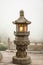 Close up stone Chinese Buddhist lamp with light inside near big buddha in Hong Kong.