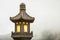 Close up stone Chinese Buddhist lamp with light inside near big buddha in Hong Kong.