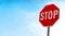 Close up of stop traffic sign with cloudy blue sky