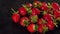 Close-up of strawberries on a wet black surface.