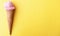 Close up strawberry ice cream in waffles cone on yellow background. Copy space